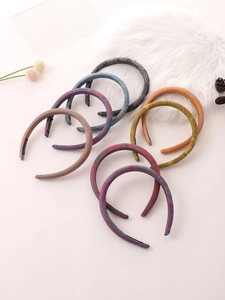 Detail showing an 8-piece set of handmade paisley pattern headbands in various colors
