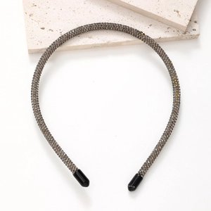 Macro shot of thin headband with sparkling dark grey rhinestones and protective end caps
