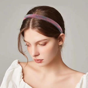 Detail of grey satin headband with red floral embroidery shown on a model