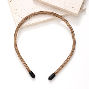 Detail of slim champagne gold headband with sparkling rhinestones and protective end caps
