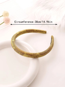 Detail view of a golden paisley satin sponge headband with 38cm circumference measurement