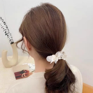 Elegant white pearl and organza hair scrunchie shown as a stylish low ponytail accessory