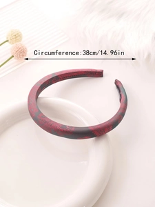 Close-up of paisley pattern satin headband on ceramic plate with 38cm size text label