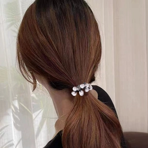 Eleganter weißer Perlenhaargummi an einem braunen Pferdeschwanz für ein minimalistisches Styling