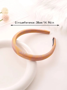 Detail showing orange cashew flower headband inner 38cm circumference and satin texture