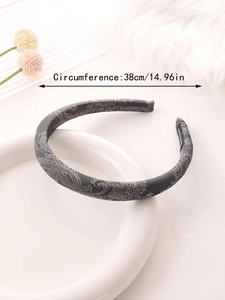 Detail view of paisley pattern headband with 38cm circumference on white plate