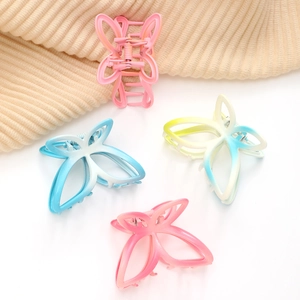 Chic butterfly hair claw clips in assorted gradient colors on a white minimalist backdrop