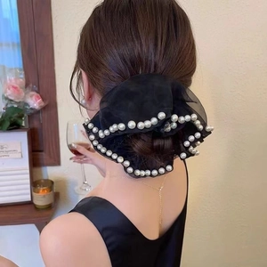 Elegant black organza scrunchie with white pearls worn on a low ponytail hair style