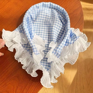 Detail of blue and white checkered scarf featuring elegant multi-layer lace trim edges
