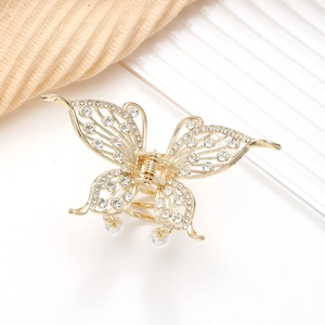 Detailaufnahme der goldenen Schmetterlings-Haarklammer mit Strass und Perlenanhängern