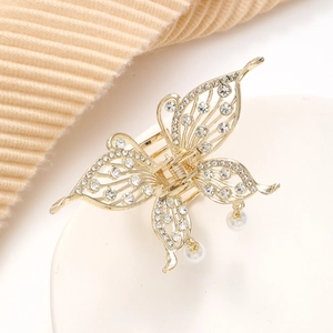 Detail einer goldenen Schmetterlings-Haarklammer mit Strasssteinen und Perlenanhänger