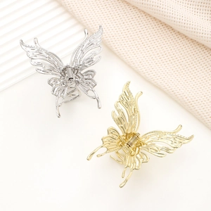 Nahaufnahme von goldenen und silbernen Schmetterlings-Haarklammern mit Cut-out-Flügeln