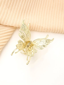 Nahaufnahme einer goldenen Schmetterlings-Haarklammer mit hohlen Flügeln und Feder