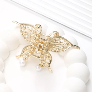 Detailansicht einer goldenen Schmetterlings-Haarklammer mit Perlenanhängern und Metallflügeln