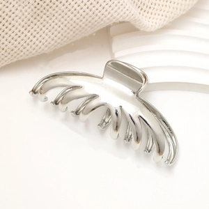 Detailed macro view of large silver metal hair claw clip with a high-shine mirror finish