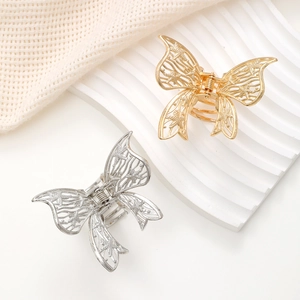 Nahaufnahme goldener und silberner Schmetterlings-Haarklammern mit Strass und Hohlmuster