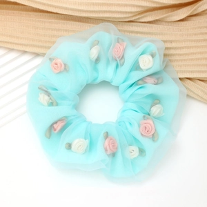 Detail van lichtblauwe mesh haarelastiek versierd met roze en witte stoffen roosjes