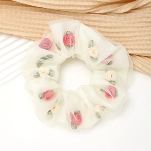 Detailopname van de dubbellaagse organza scrunchie met kleine stoffen rozen decoraties