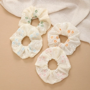 Elegant floral chiffon hair scrunchies with delicate flower embroidery on wood background