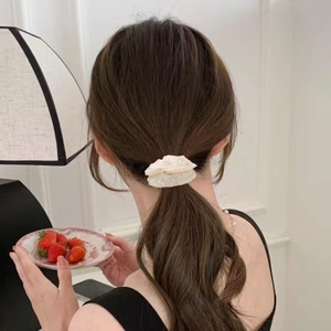 Creamy floral chiffon scrunchie with pink embroidery detail on model low ponytail hair