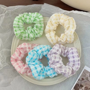 Détail de cinq chouchous à carreaux colorés en vert menthe et tons pastels