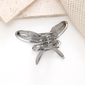 Detaillierte Makroansicht der silbernen Schmetterlings-Haarklammer mit glänzendem Metall-Finish