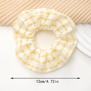 Détail d'un chouchou à carreaux jaunes montrant la texture du tissu et la taille de 12cm