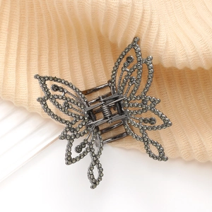 Vue détaillée de la pince à cheveux papillon avec strass gris et ailes en métal