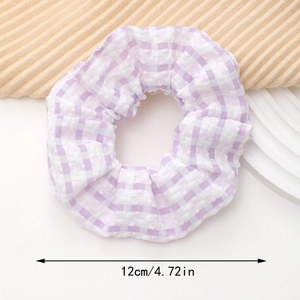 Détail d'un chouchou à carreaux violets de 12 cm avec texture plissée douce