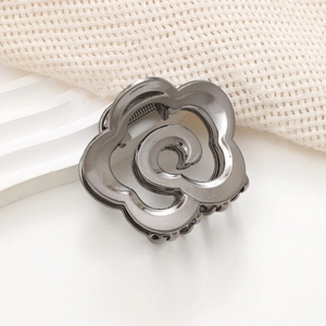 Vue détaillée d'une pince à cheveux en métal gris foncé avec design floral sculpté