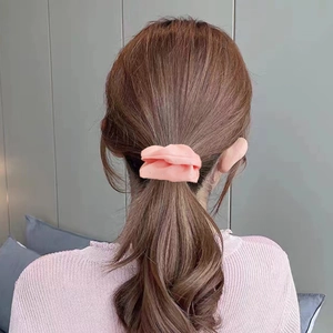 Detail view of light pink fabric scrunchie with rhinestones on a low ponytail