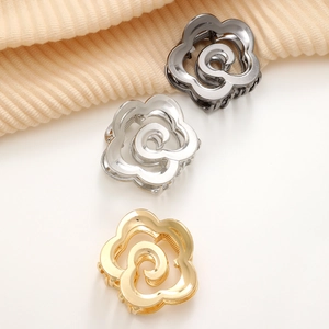 Vue détaillée de pinces à cheveux en métal en forme de rose en or, argent et noir fusil