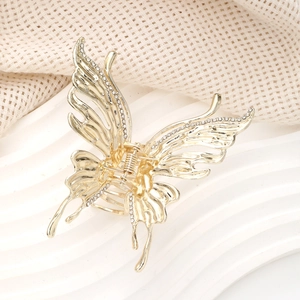 Détails de la pince à cheveux papillon dorée avec strass brillants et design creux