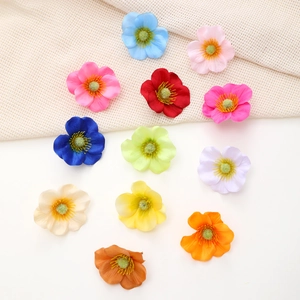Detailed view of colorful fabric silk flower hair clips with realistic yellow stamens