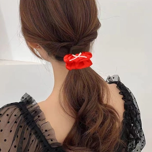 Chouchou élégant en satin rouge avec cordon blanc sur une coiffure en queue de cheval basse
