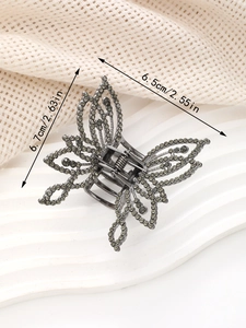 Détail d'une pince à cheveux papillon évidée avec strass gris, taille 6,7cm x 6,5cm