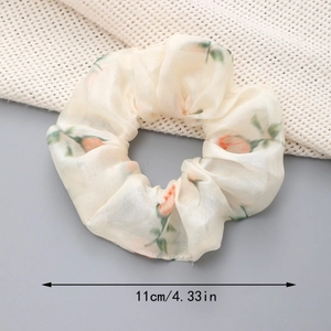 Détail du chouchou en organza aux fleurs orange avec un diamètre de 11 cm pour cheveux