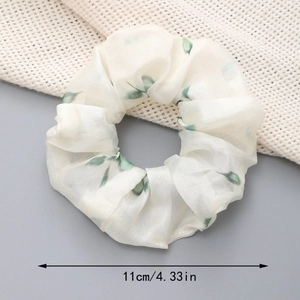 Détail du chouchou en organza floral avec imprimé feuilles et mesure de 11 cm de diamètre