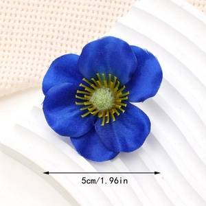 Macro detail of a 5cm blue fabric silk flower hair clip with realistic satin petals