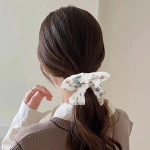 Detail view of a white hair scrunchie with colorful butterfly prints on a model hair