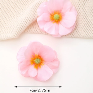 Detail view showing dual 7cm pink silk flower hair clips with rich fabric texture