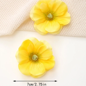 Detail showing a 7cm yellow fabric silk flower hair clip with layered petals and soft stamen