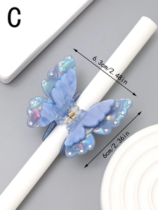 Detailed view of light blue butterfly hair claw clip with rhinestones and marble texture