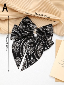 Détail du grand nœud papillon en mousseline noire à motif cachemire et perles blanches, 23cm