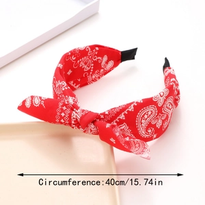 Detail view of red paisley bow headband with 40cm circumference measurement and black tips