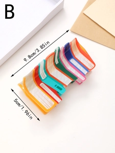 Close-up of a book-shaped acrylic hair claw clip with colorful stacked design details