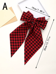 Detail view of large red plaid bow hair clip measuring 19cm by 35cm with long streamers