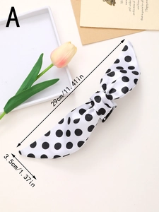 Detailed size specifications for the polka dot bow hair clip shown on a soft cream background