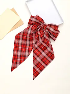 Detail view of red plaid bow hair clip with long ribbons and size measurements