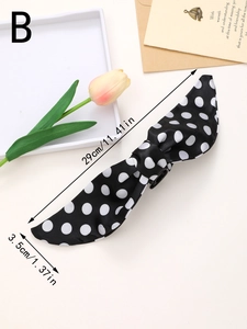 Detailed view of large black polka dot bow hair clip with measurement labels in inches